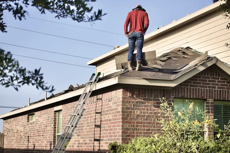 Professional roofer working on a residential roof in Garden City